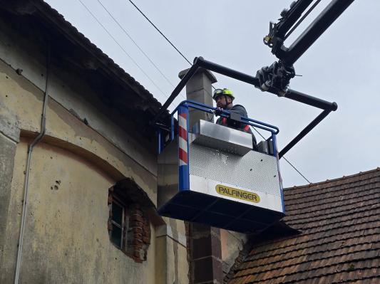 FOTO: Sanacija po vetru razkriva poškodovane strehe in podrta drevesa